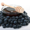 Blueberry seed oil in glass bowl with blueberries