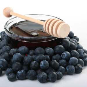 Blueberry seed oil in glass bowl with blueberries