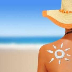 Woman sitting on beach in bikini and sun hat