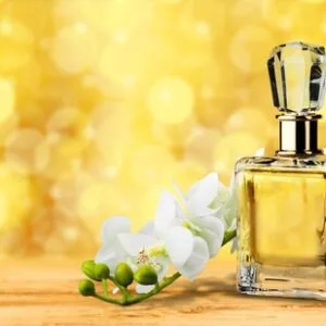Perfume bottle on a yellow background with white flower