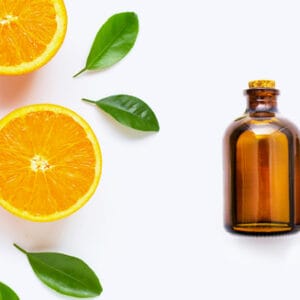 Oranges with amber glass bottle on white background